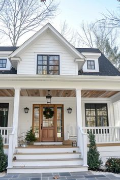 a white house with black shutters on the front door and steps leading up to it