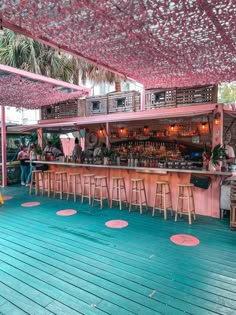 an outdoor bar with lots of stools and tables