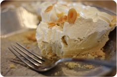 a piece of pie sitting on top of a metal plate with a fork next to it