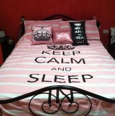 a bed with pink and white comforter, pillows and pillowcases on it