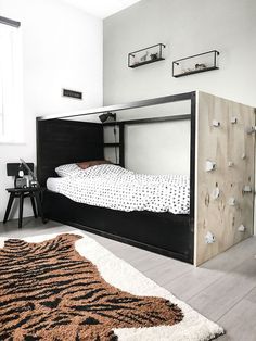 a black and white bedroom with an animal print rug on the floor next to a bed