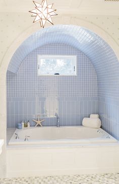 a white bath tub sitting under a window next to a starfish