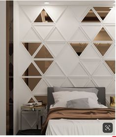 a modern bedroom with white walls and geometric shapes on the wall, along with an upholstered bed