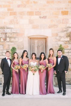 a group of people standing next to each other in front of a building with flowers