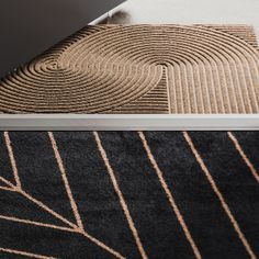 a laptop computer sitting on top of a rug next to a black and white area rug