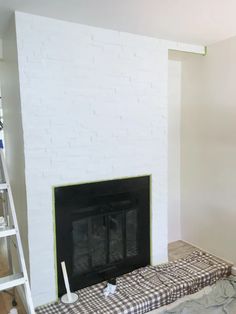 the fireplace is being painted and ready to be installed in the living room with white walls