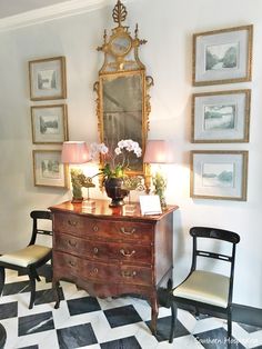 a room with a dresser, chair and mirror on the wall next to two lamps