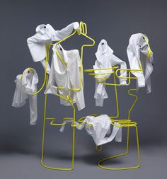 an image of clothes hanging on racks and drying them in the air with yellow wire