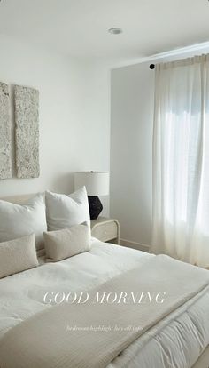 a bedroom with white bedding and curtains