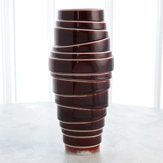 a stack of brown cups sitting on top of a white table next to a window