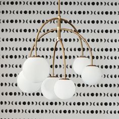 a chandelier with five white balls hanging from it