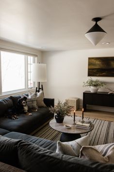 a living room with two couches and a coffee table in front of a window