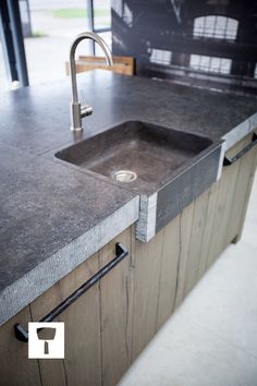 a kitchen sink sitting under a faucet next to a counter top with a metal faucet