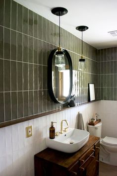 a white sink sitting under a mirror in a bathroom next to a wooden counter top