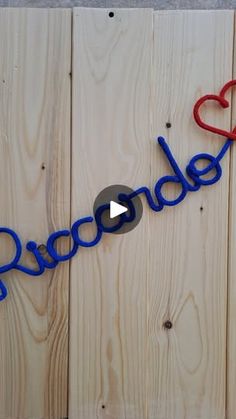 the word doodle spelled out in blue and red yarn with two hearts on it