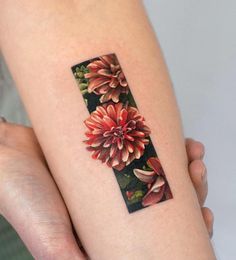 a woman's arm with a flower tattoo on it