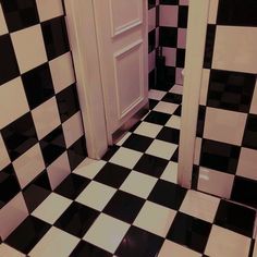 a black and white checkered tile floor in a room with two open doors on either side