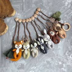 several small stuffed animals are hanging from a string on a white surface with wood beads