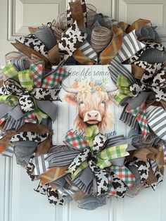 a wreath with a cow on it hanging from the front door