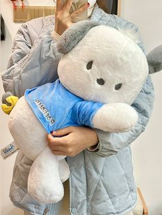 a woman holding a large white teddy bear in her arms while taking a selfie