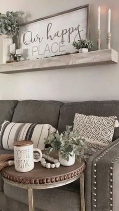 a living room with a couch, coffee table and two candles on the side tables