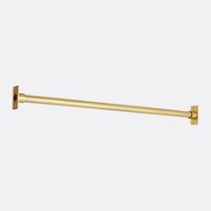 an image of a brass towel bar on a white wall with the handle in gold