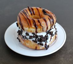 two donuts covered in chocolate and white frosting on top of a white plate