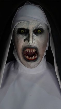 a creepy nun with green eyes and white makeup