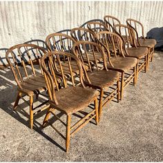 six wooden chairs lined up against a wall