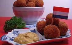 two plates with food on them and a flag in the bowl next to one plate