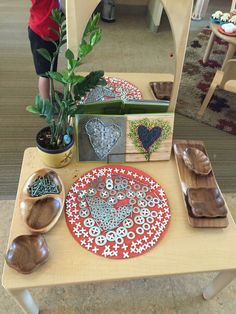 a wooden table topped with plates and bowls on top of it next to a mirror