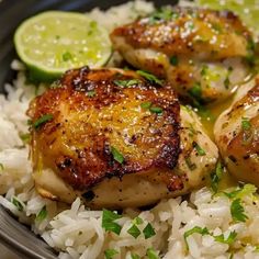 some chicken and rice in a bowl with lime wedges