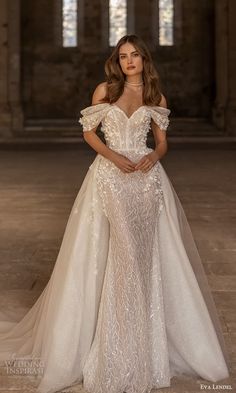 a woman in a white wedding dress posing for the camera with her hands on her hips