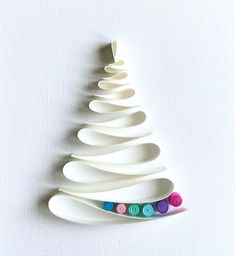 a white ceramic christmas tree with buttons on it's sides and the shape of an ornament