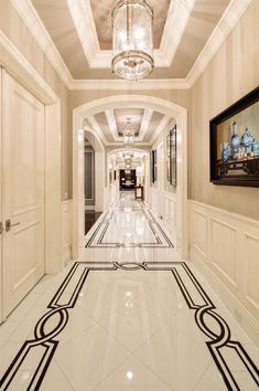 an elegant hallway with chandelier and marble flooring is seen in this image