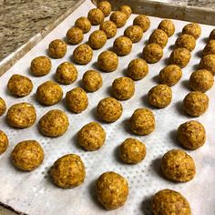 some balls of food are sitting on a baking sheet and ready to go into the oven