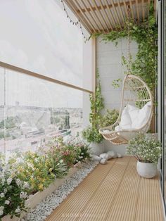 a white hanging chair on a balcony next to flowers