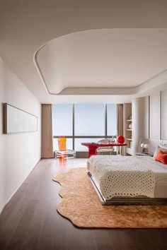 a bedroom with a large bed sitting on top of a hard wood floor next to a window