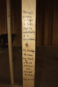 a wooden pole with writing on it in a room that is being built into the wall