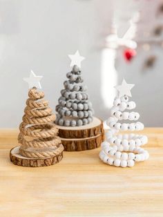 three small wooden christmas trees sitting on top of a table