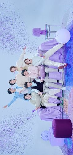 a group of people standing next to each other in front of a purple and blue background