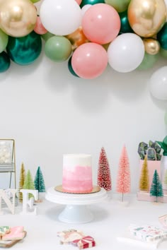 a table topped with a cake and balloons