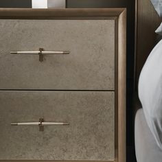 two drawers with handles on each side of a bed and a night stand next to it