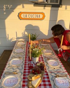 the woman is setting the table outside for dinner