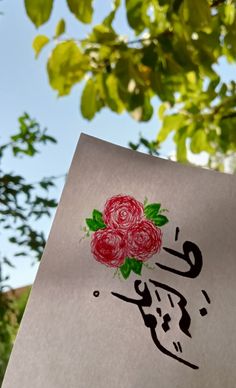 a piece of paper that has some writing on it with flowers painted on it and leaves in the background