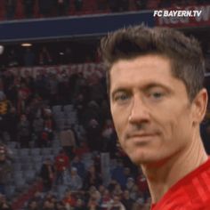 a close up of a soccer player wearing a red uniform and looking at the camera