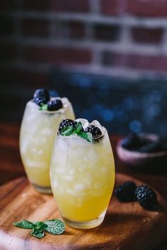 two glasses filled with lemonade and blackberries