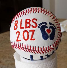 a close up of a baseball on top of a toilet paper dispenser