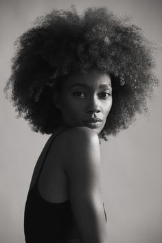 a black and white photo of a woman with an afro