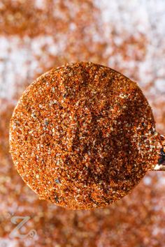 an orange ornament hanging from a tree with lots of brown and white speckles